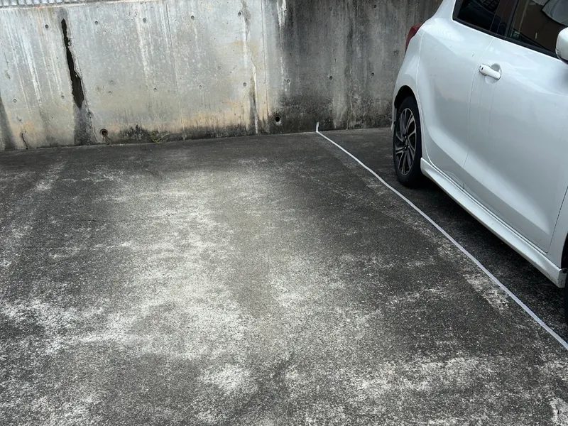 浜松市で駐車場の高圧洗浄を行う前、黒ずみやカビ汚れが目立つコンクリート面